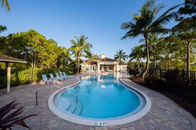 Resort-style heated swimming pool with plenty of seating, and shaded pavilion adjacent to pool. 